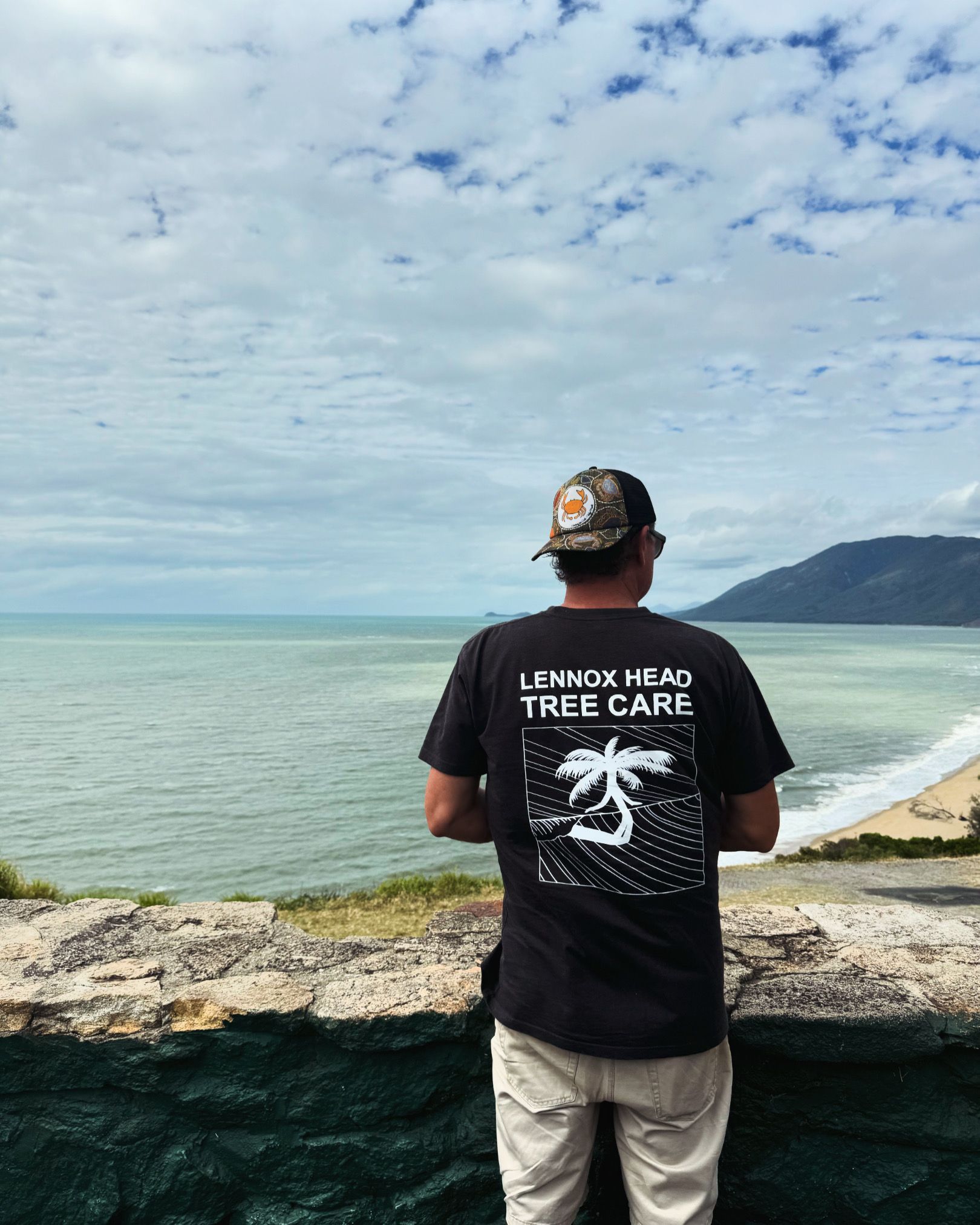 A Man Is Cutting A Tree Branch With A Chainsaw — Lennox Head Tree Care In Lennox Head, NSW