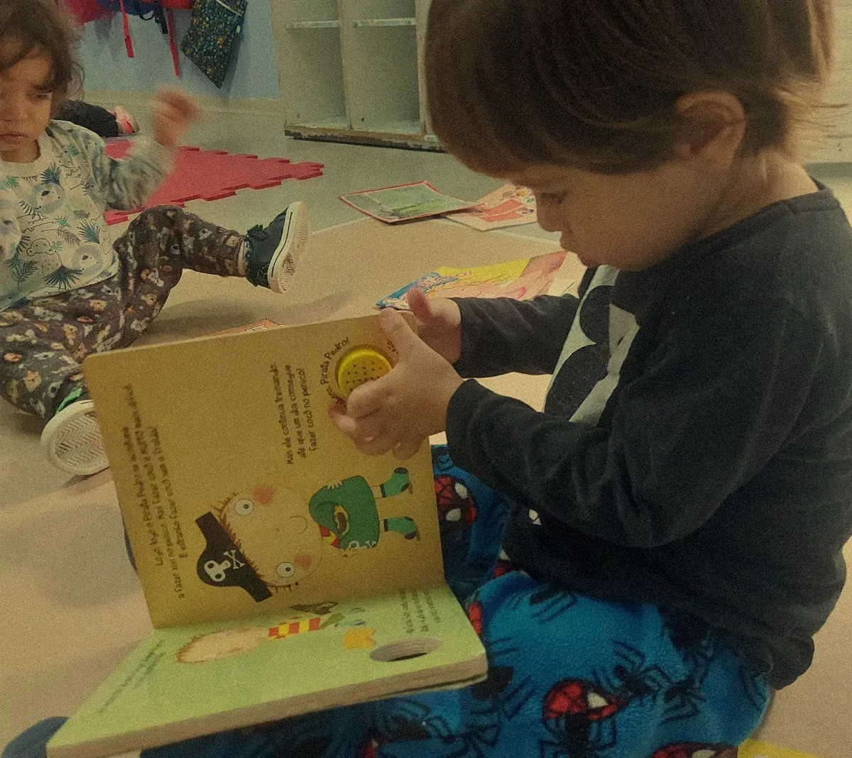 Um garotinho está lendo um livro com um pirata nele