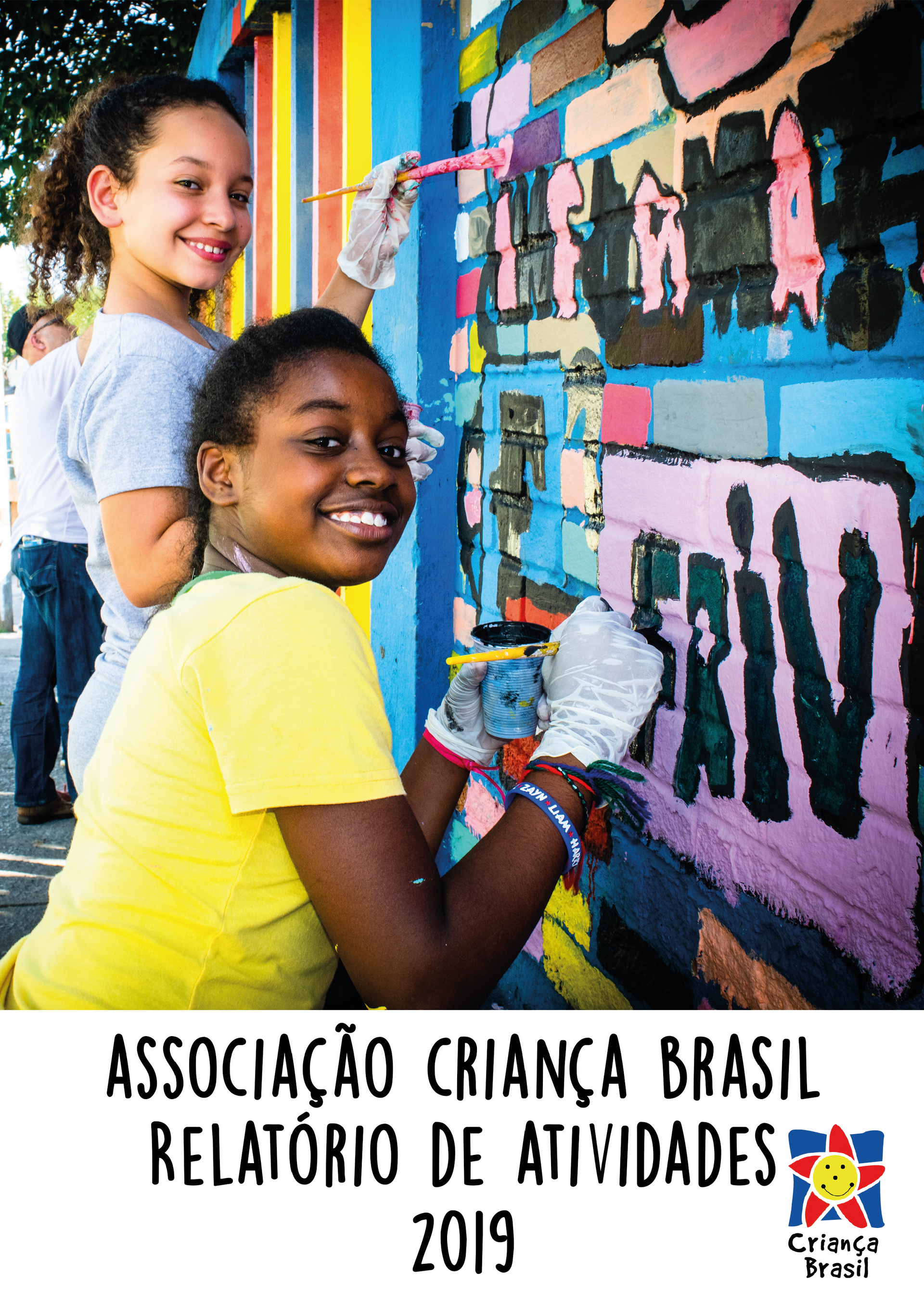 Duas meninas estão pintando uma parede com um pincel.