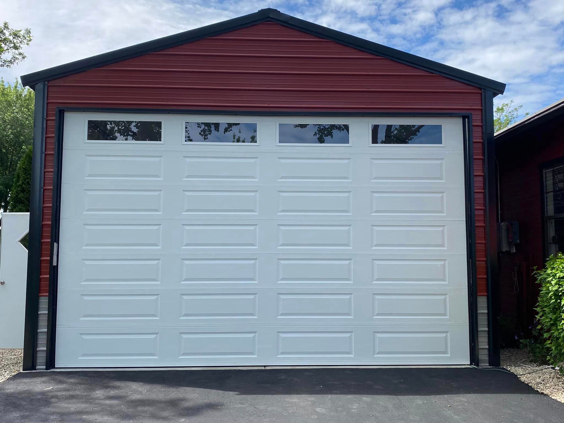 A red garage with a white door and windows.