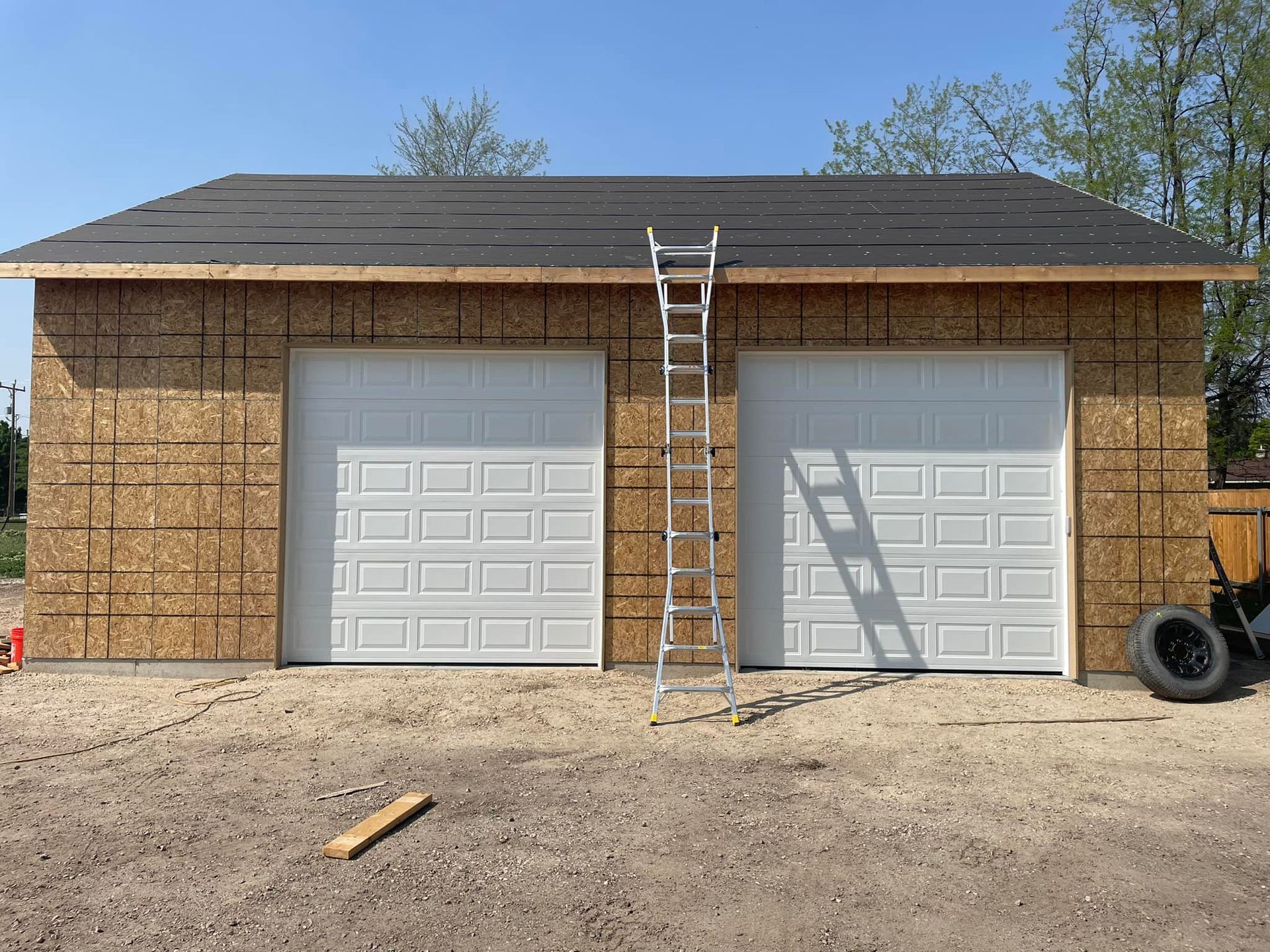 A ladder is attached to the side of a garage under construction