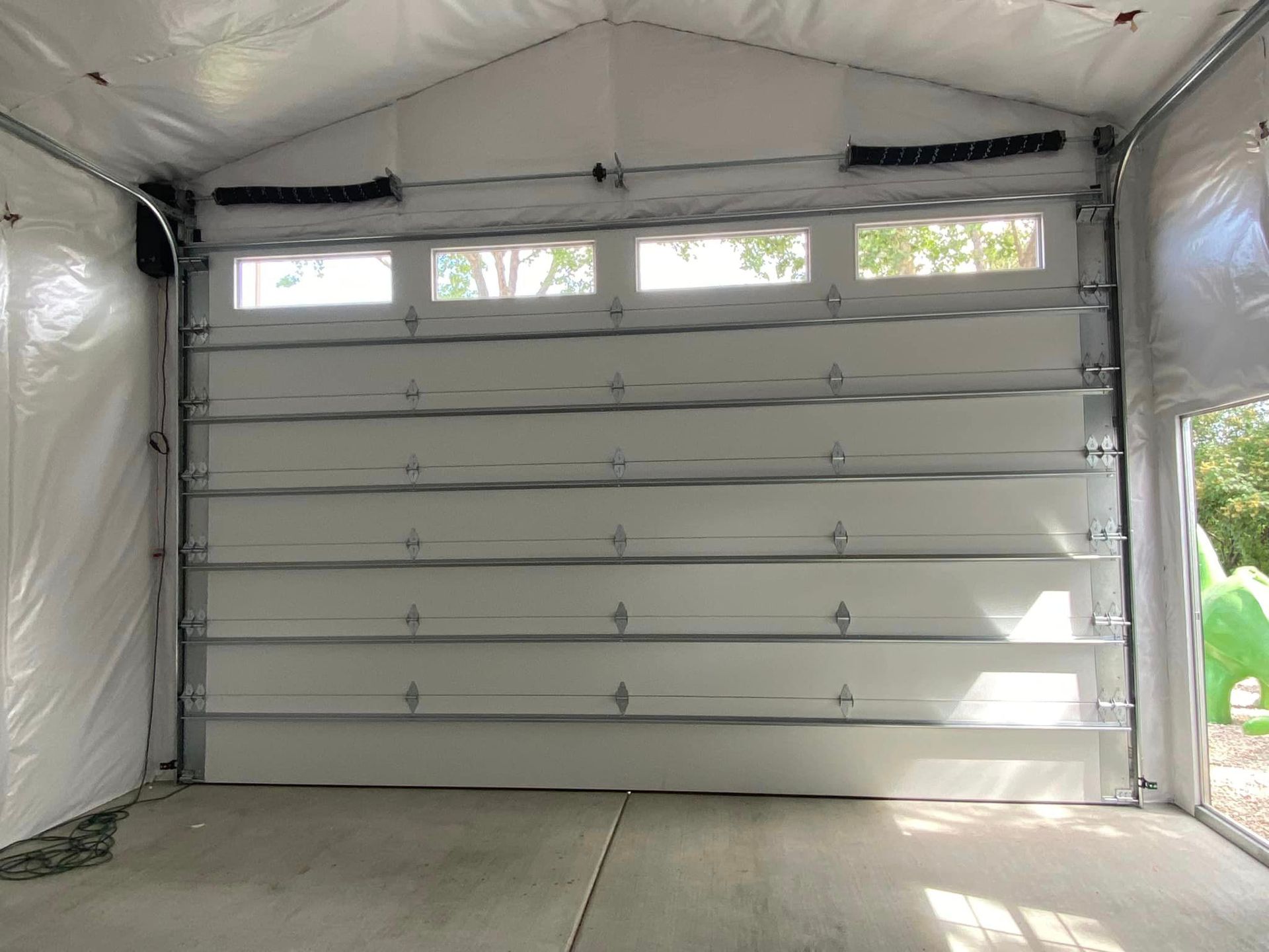 The inside of a garage with a large white garage door.