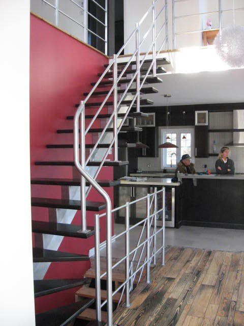 Un homme est assis à un comptoir dans une cuisine à côté d'un escalier