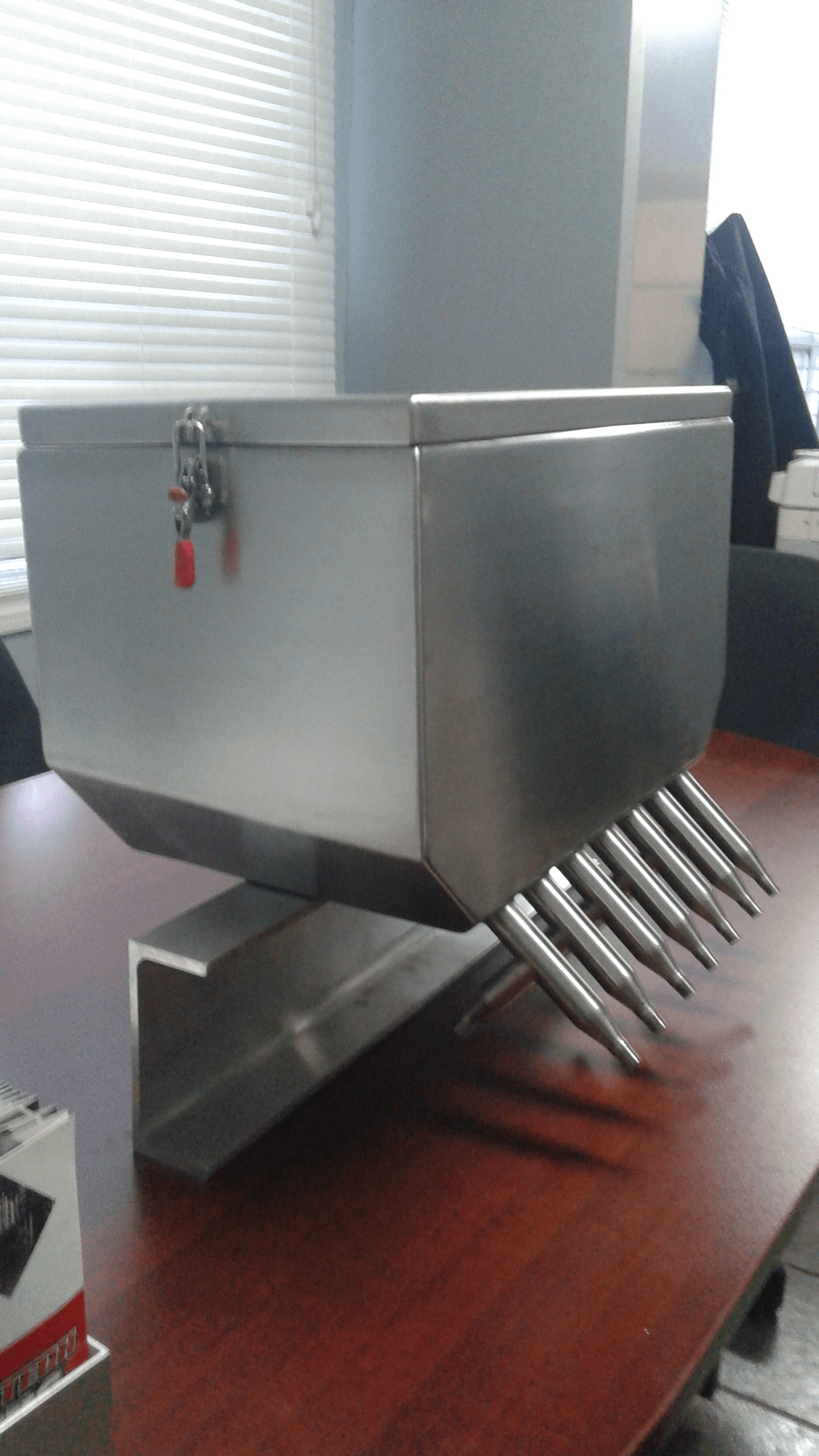 Une boîte en acier inoxydable est posée sur une table en bois.