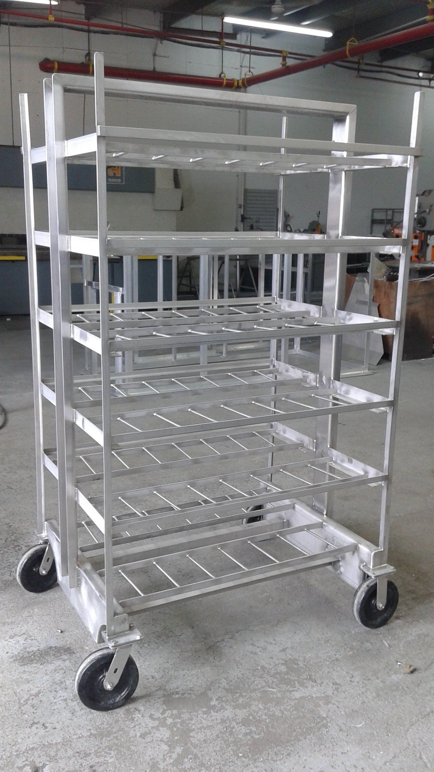 Un chariot métallique à roues repose sur le sol dans un entrepôt.