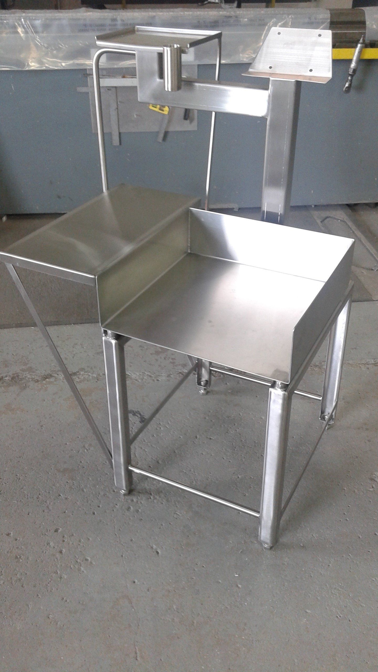 Une chaise en acier inoxydable est posée sur un sol en béton.