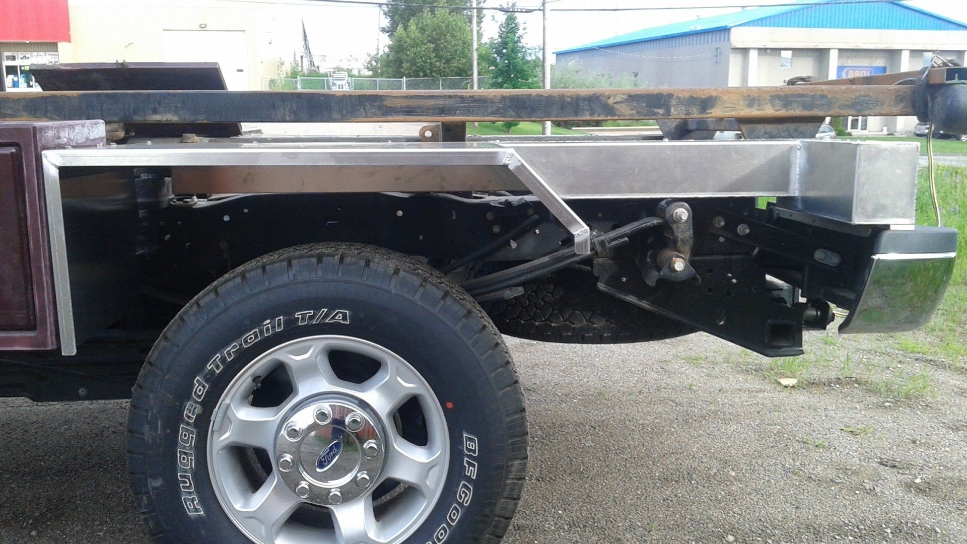 Un camion avec plateau est garé sur le bord de la route.