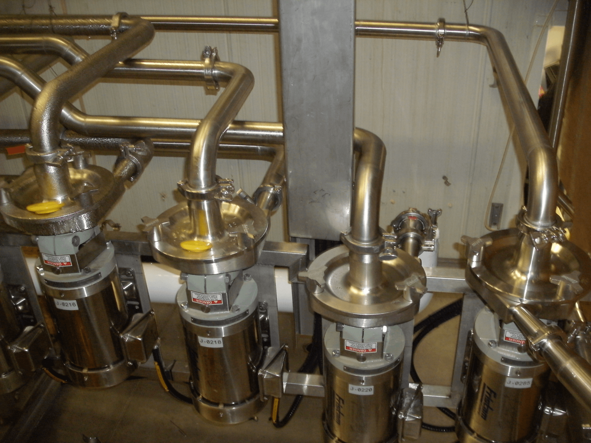 Une rangée de tuyaux en acier inoxydable est alignée dans une pièce