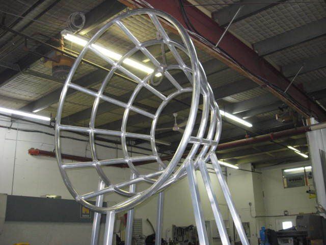 Une grande sculpture en métal est en cours de construction dans une usine