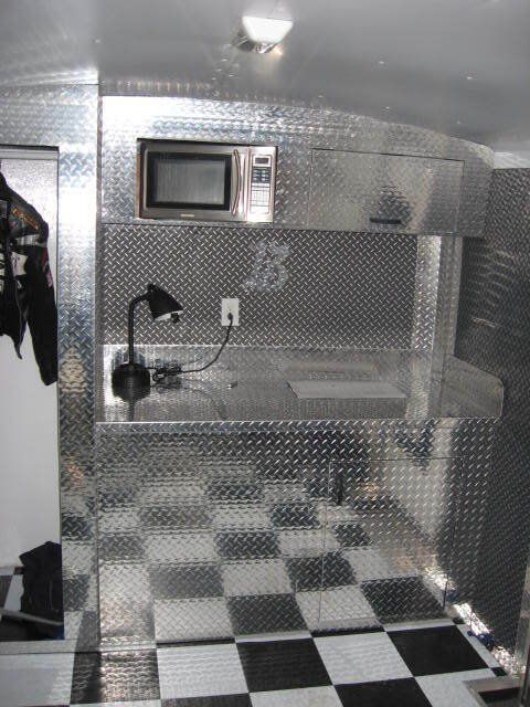 Une cuisine avec un micro-onde et un sol en damier