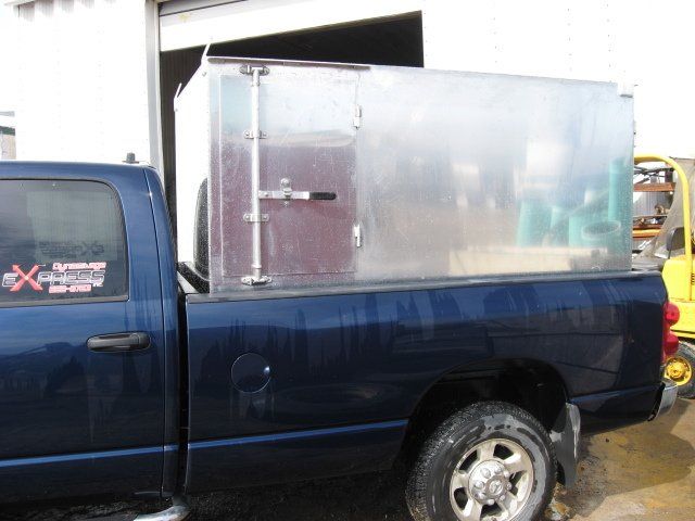 Un camion bleu avec une boîte transparente dans le lit
