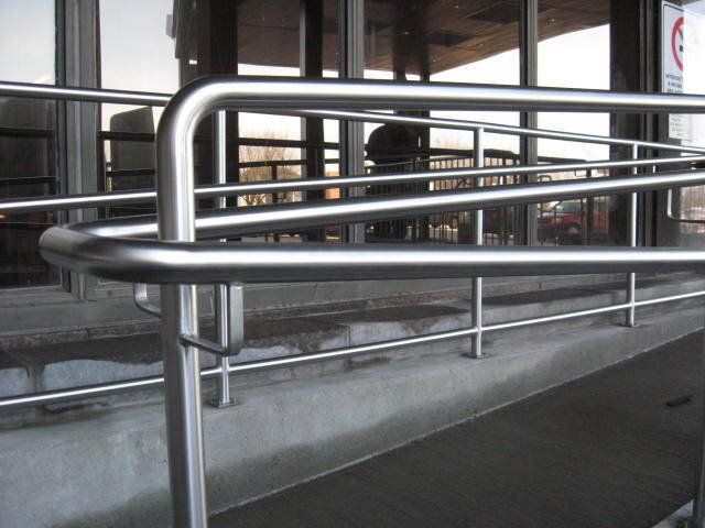 Une rampe en acier inoxydable devant un immeuble