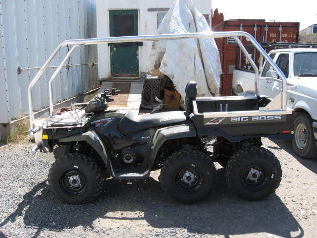 Un VTT Polaris est garé dans un terrain de gravier