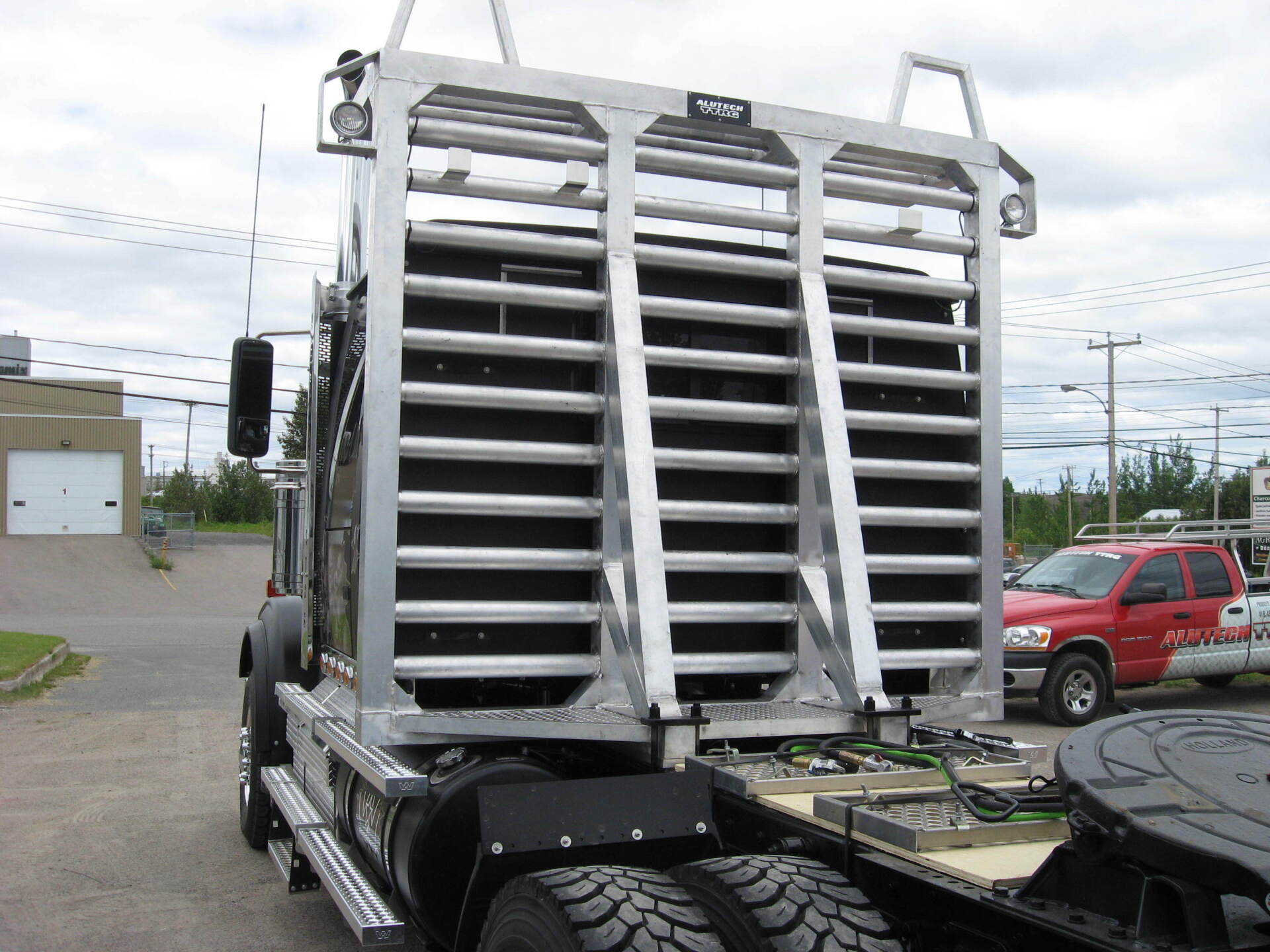 Un camion avec une cage à l'arrière est garé dans un parking