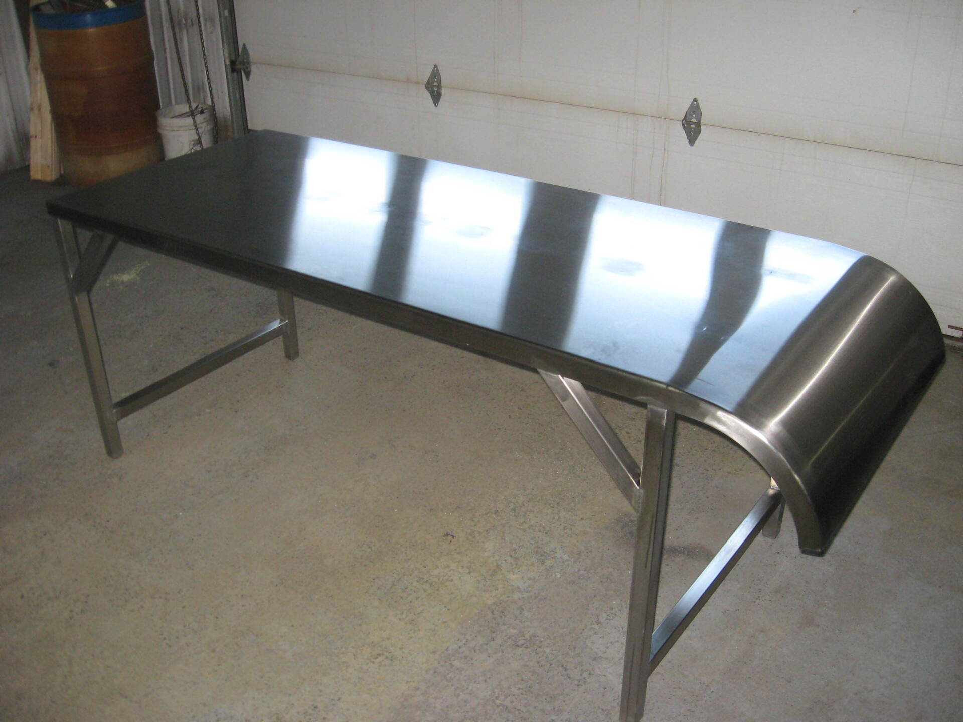Une table en acier inoxydable se trouve devant une porte de garage