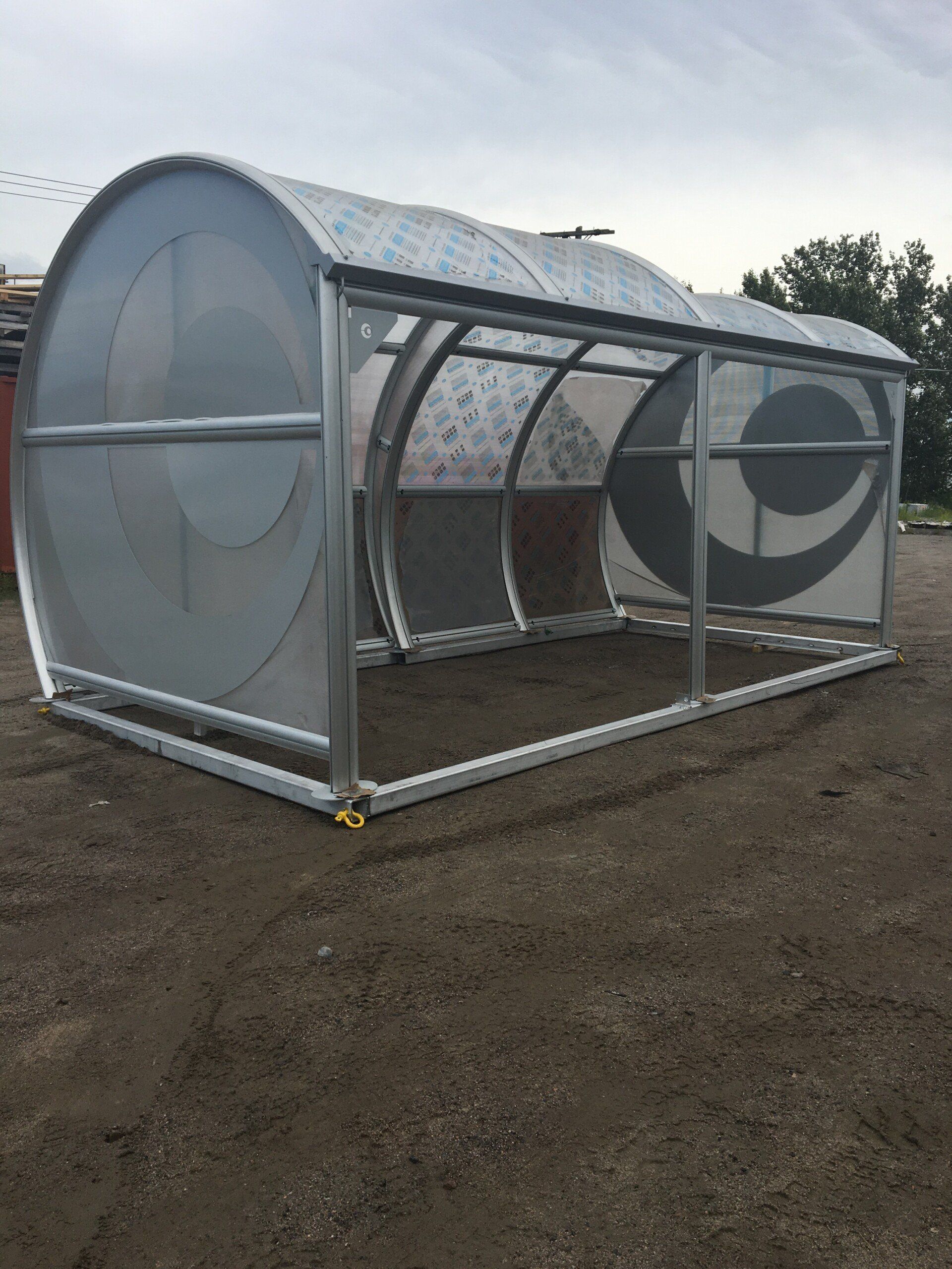 Une serre se trouve au milieu d'un champ de terre.