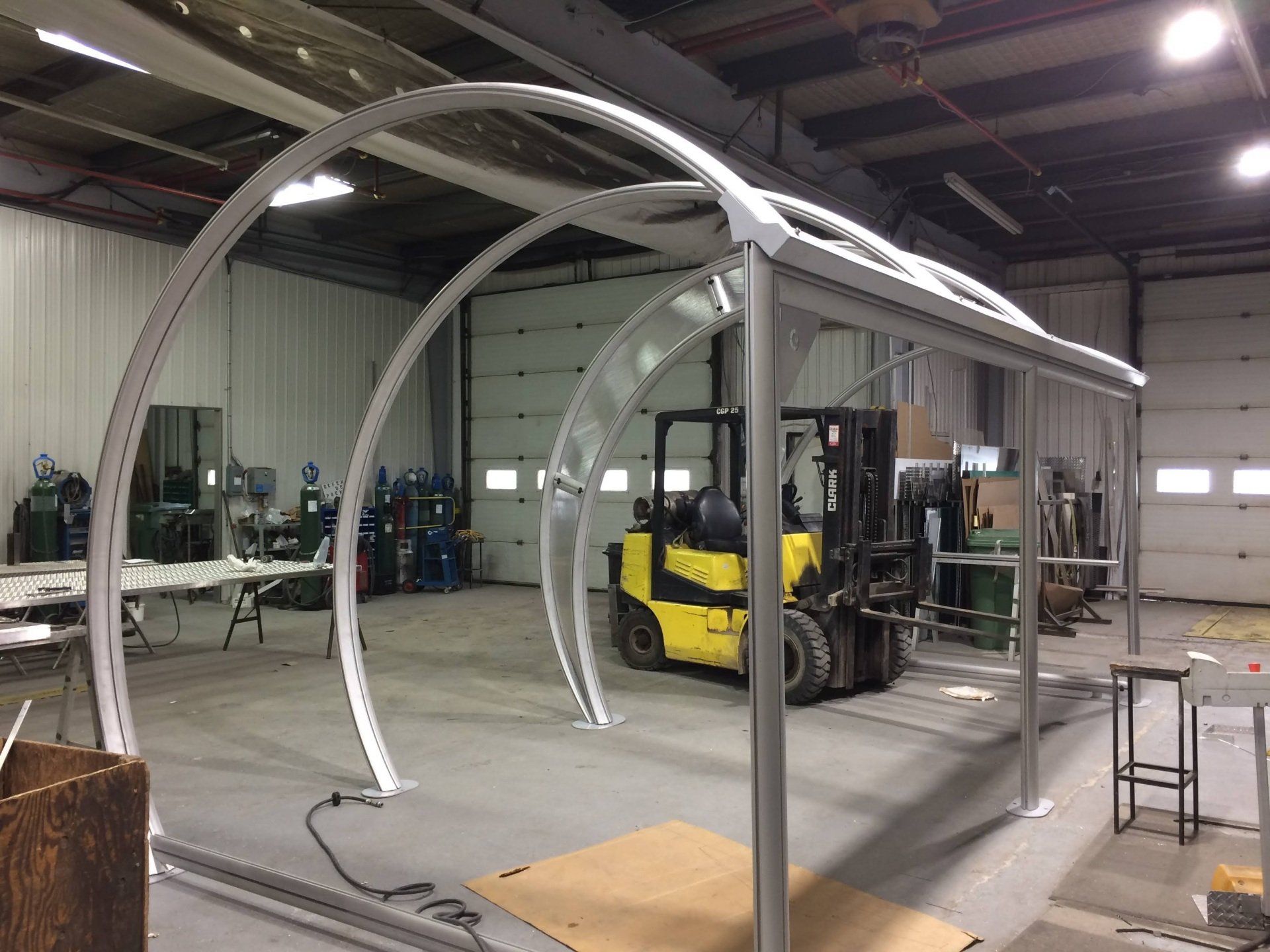 Un chariot élévateur jaune est garé dans un entrepôt à côté d'une structure métallique.