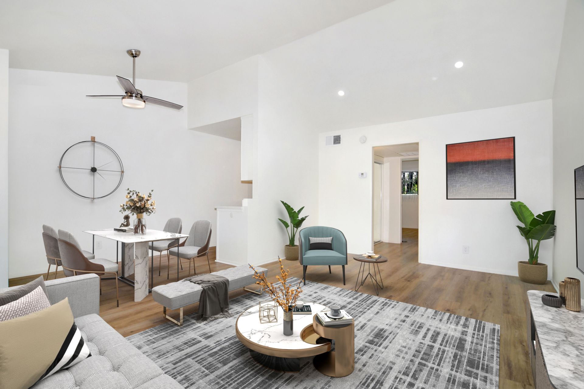 a living room with a couch , table , chairs and a ceiling fan .