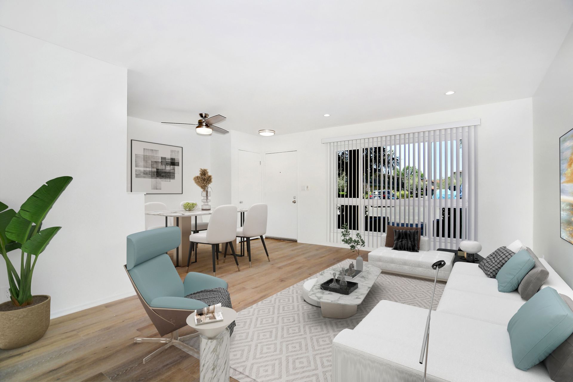 a living room with a couch , chair , table and ceiling fan .