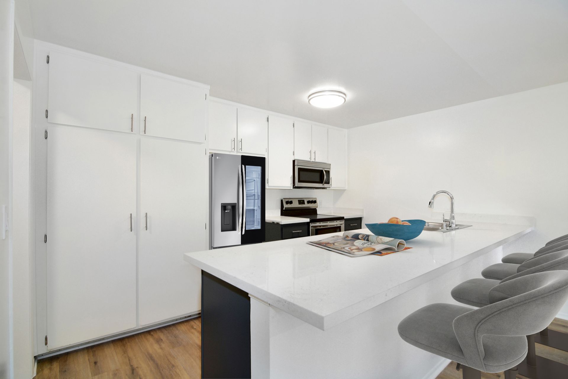 a kitchen with white cabinets , stainless steel appliances , a refrigerator and a sink .