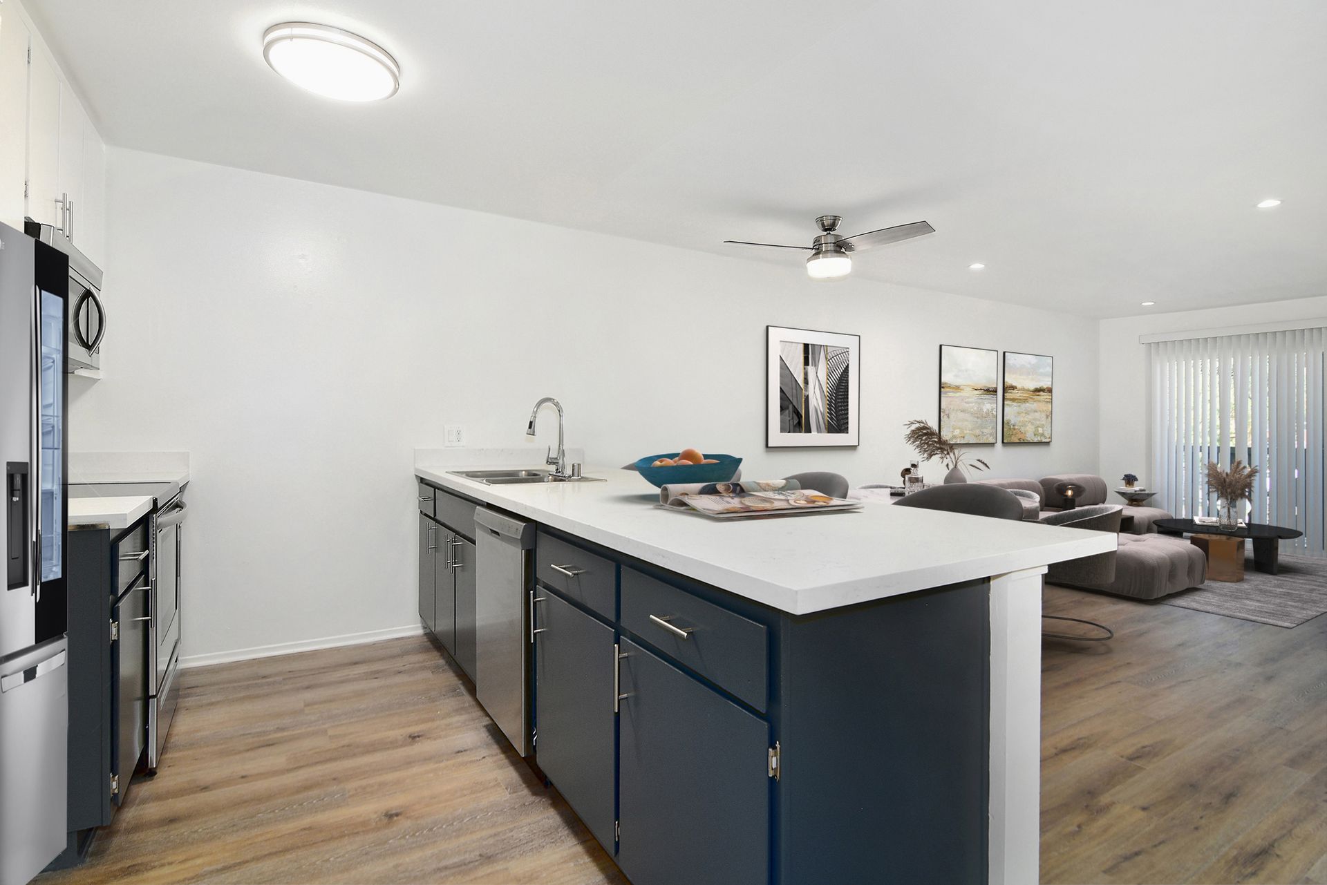 a kitchen with a large island in the middle and a living room in the background .