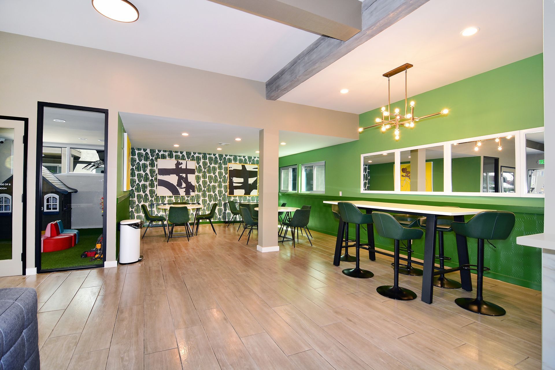 a large room with tables and chairs and a green wall .