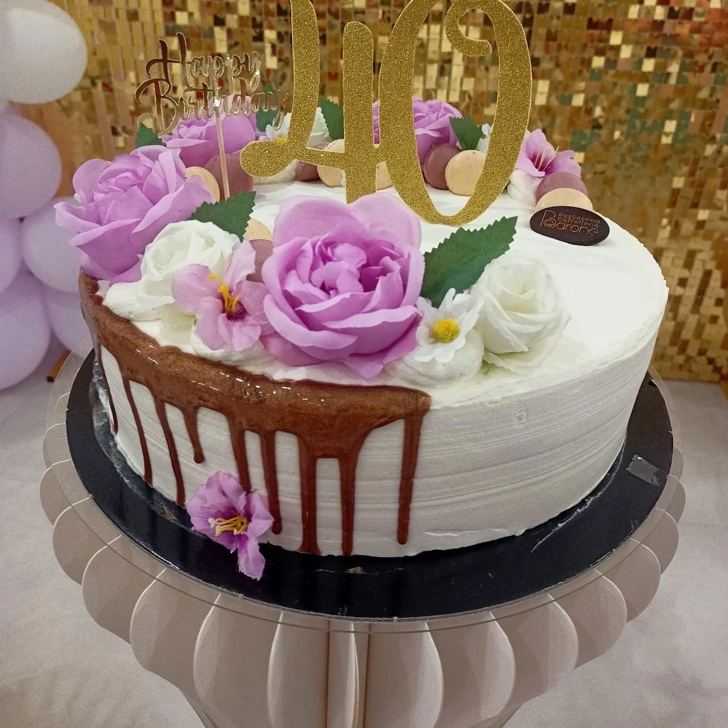 Torta con glassa, fiori e topper con la scritta 
