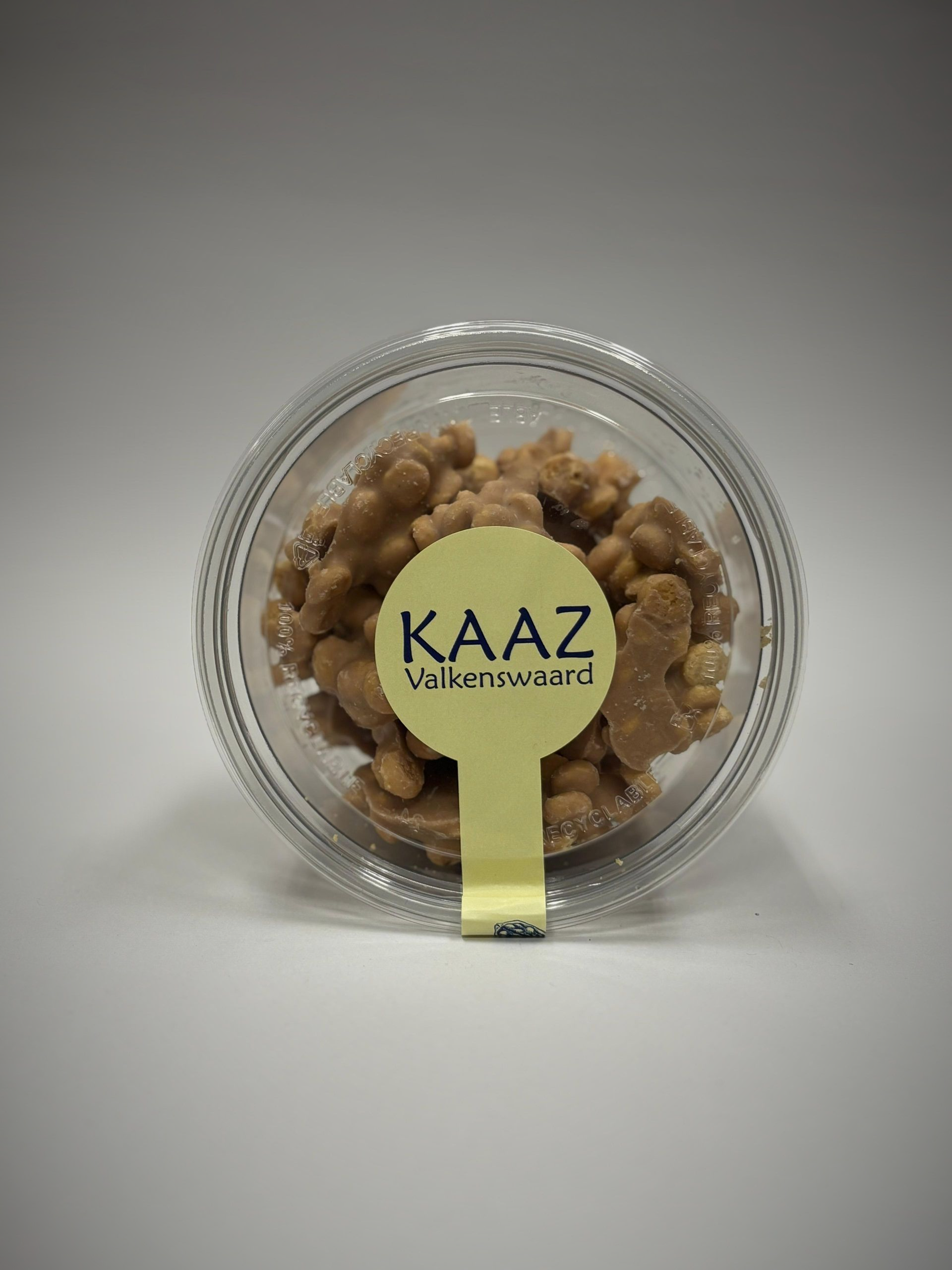 Doorzichtige verpakking met gekonfijte noten, met geel etiket 