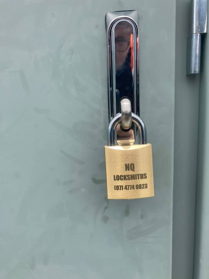 A gold padlock on a gray metal door, with the text