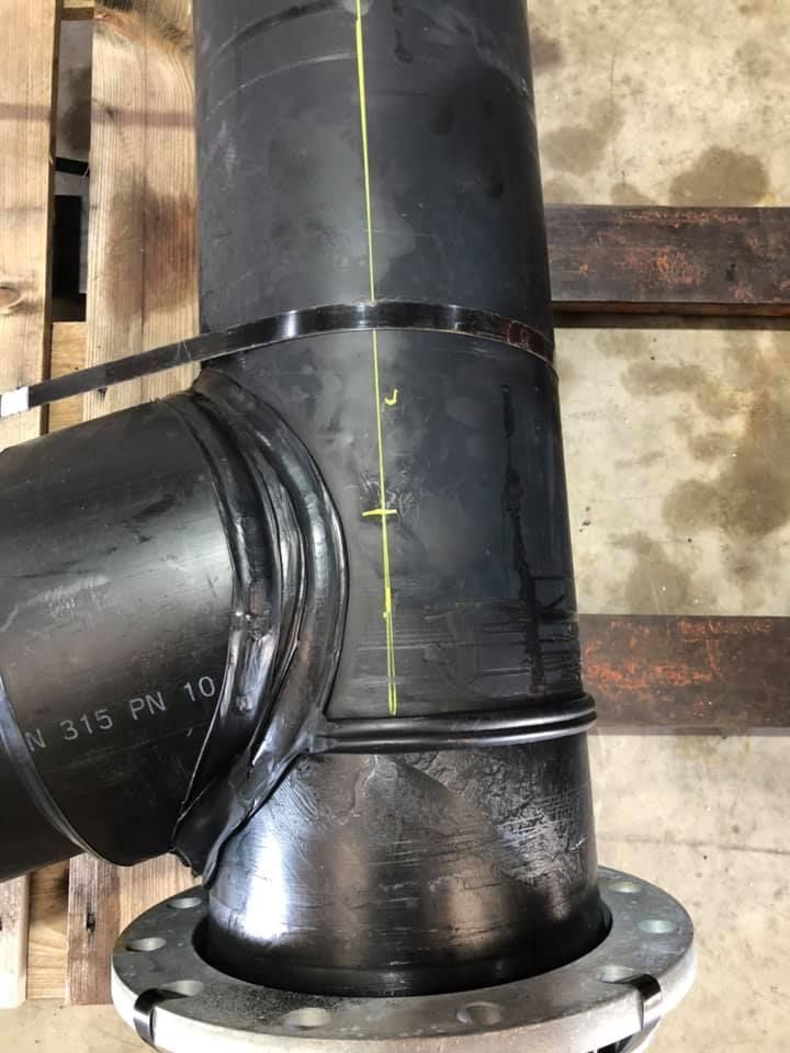 A black pipe is sitting on top of a wooden pallet. — Advanced Poly in Yarrawonga, NT