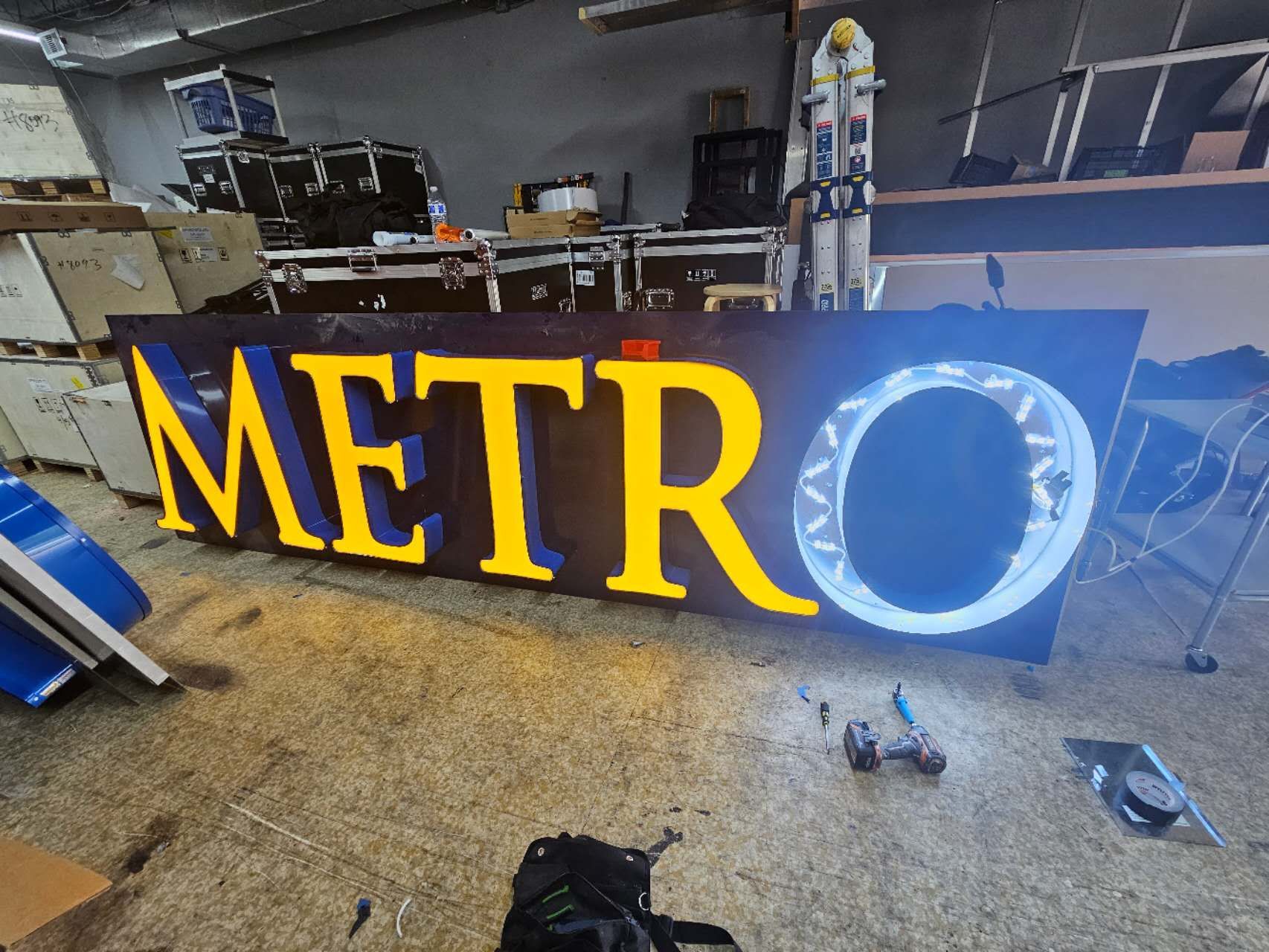 A large metro sign is sitting in a warehouse.