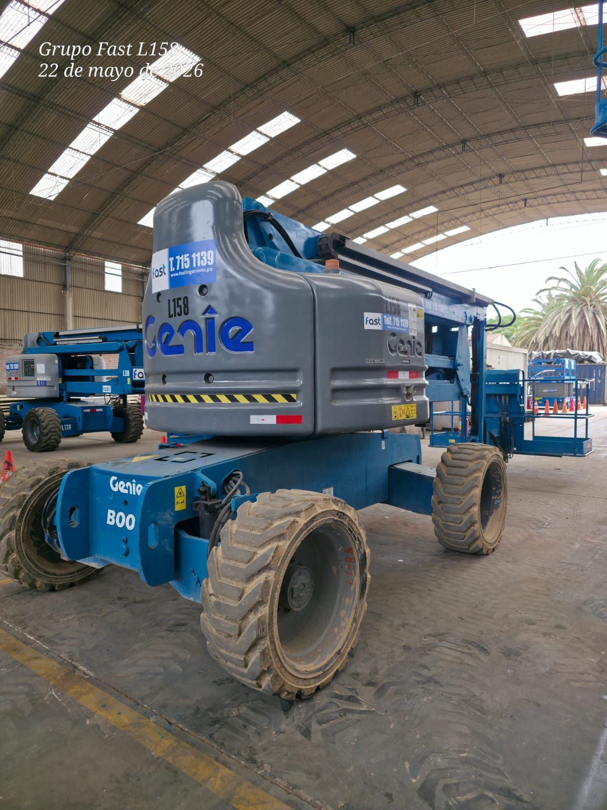 Una plataforma elevadora Blue Genie estacionada dentro de un almacén con un gran techo abovedado.