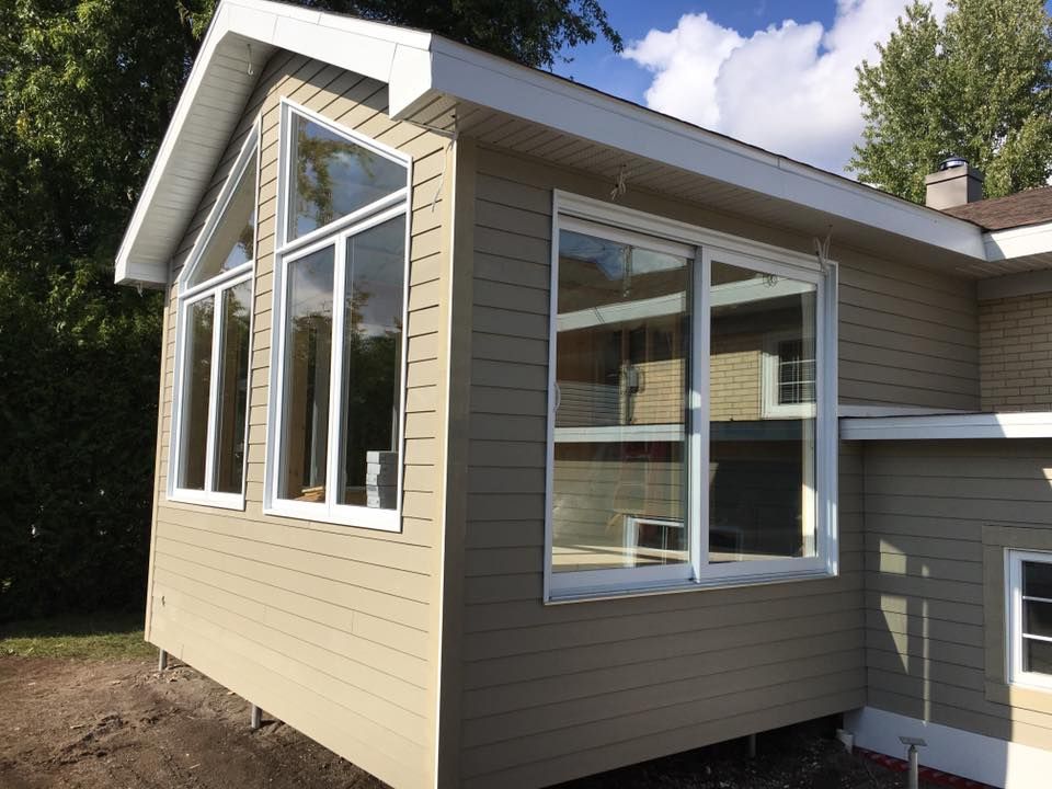 Une maison avec beaucoup de fenêtres sur le côté