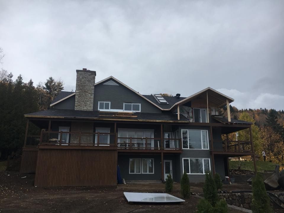 Une grande maison avec beaucoup de fenêtres et une grande terrasse.