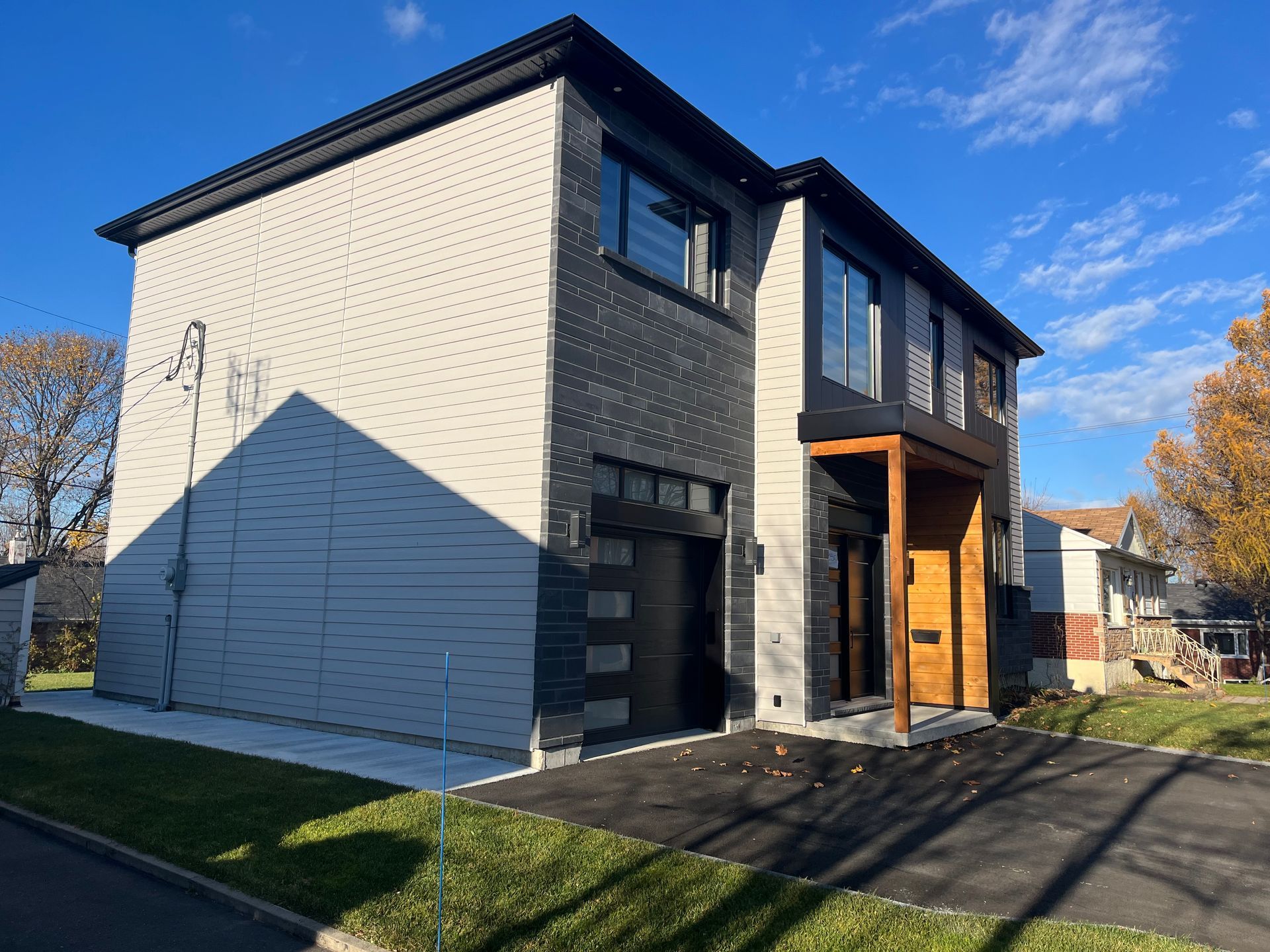 Une grande maison avec beaucoup de fenêtres est située au sommet d'une colline verdoyante.