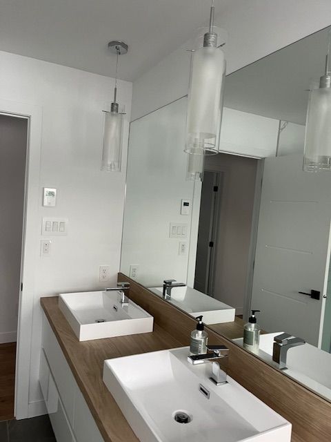 Une salle de bain avec deux lavabos et un grand miroir