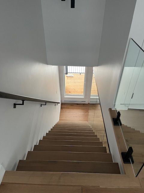 Regardant en bas d'un escalier avec une rampe en verre.