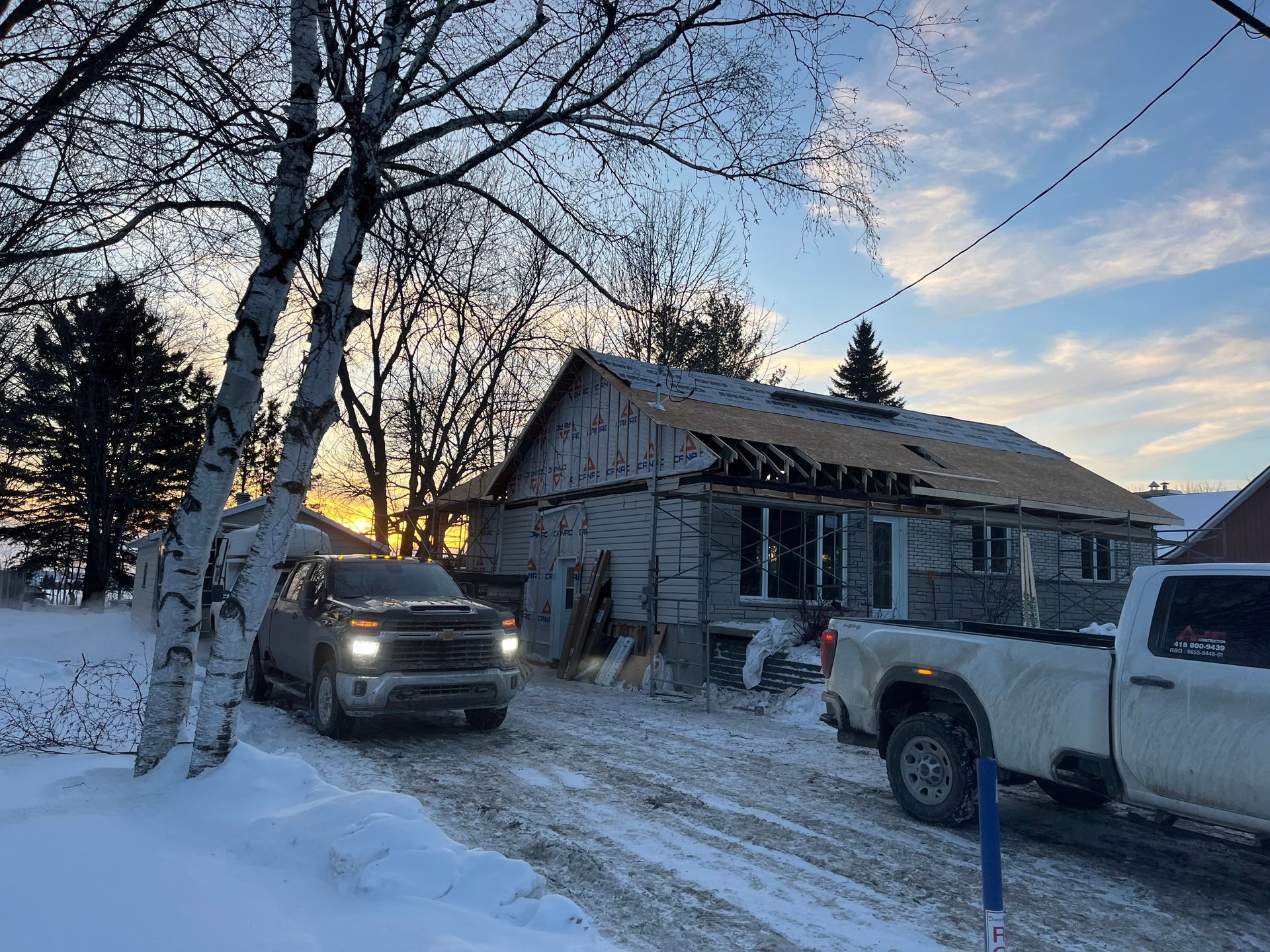 Un camion est garé devant une maison en construction sous la neige.