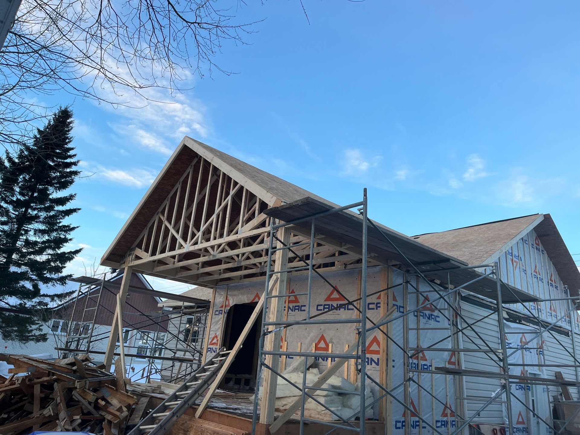 Une maison est en construction avec des échafaudages autour.