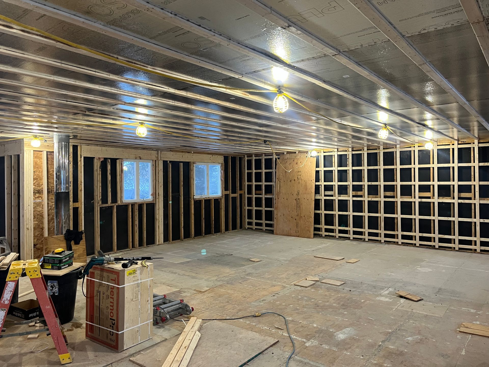 Une grande pièce avec une échelle au milieu est en cours de construction.