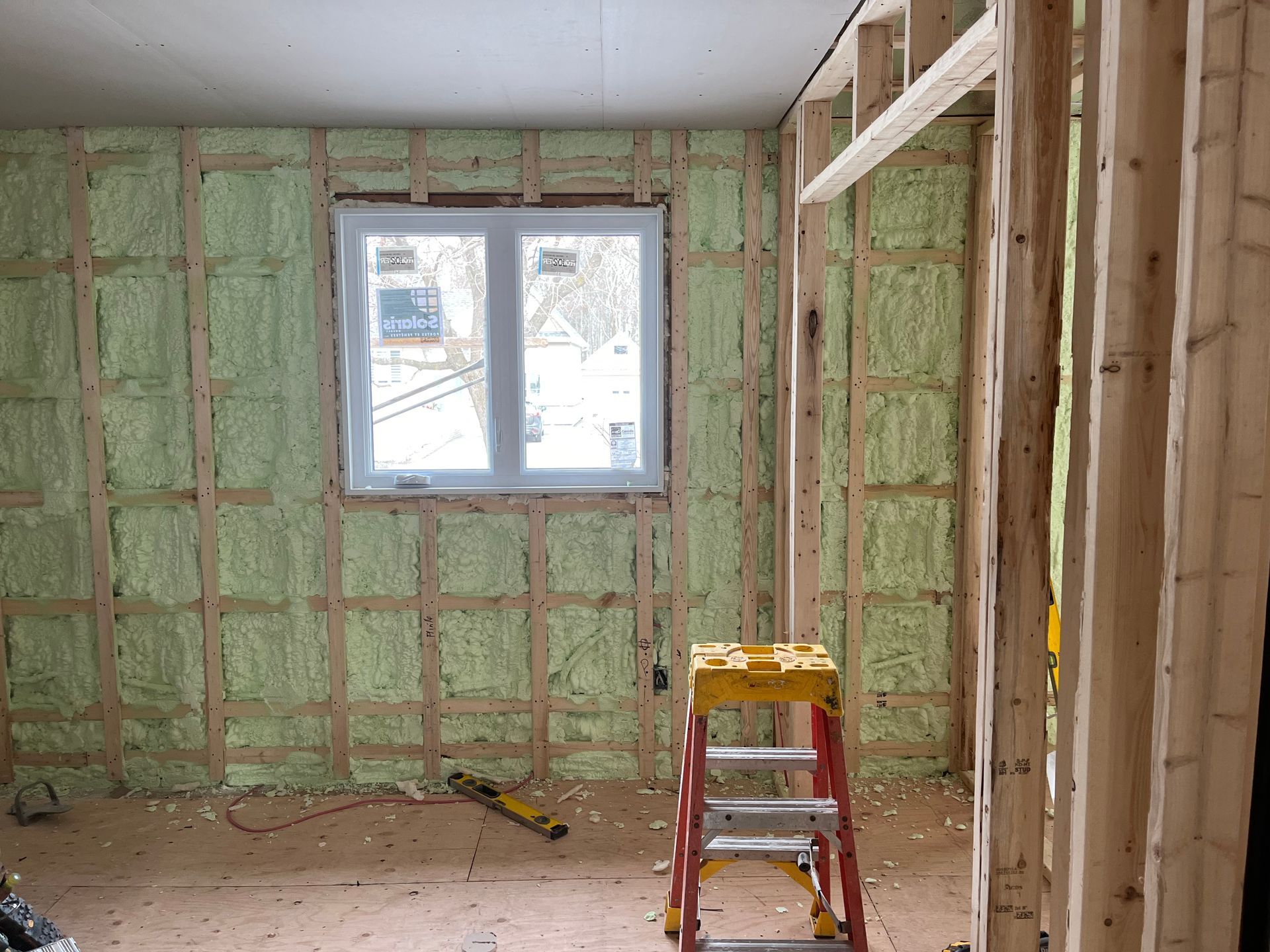 Une pièce avec une fenêtre et une échelle à l'intérieur.