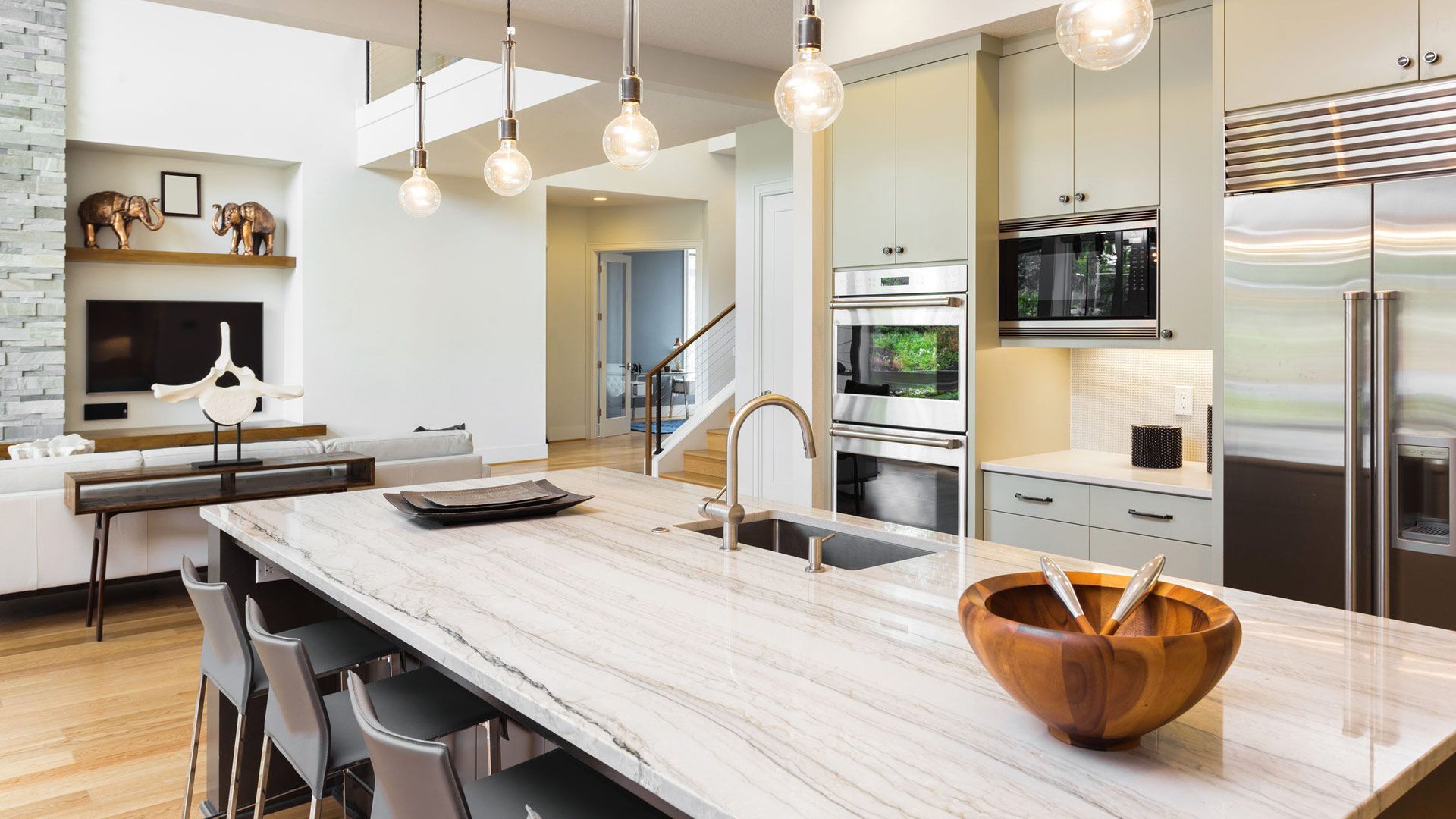 Une cuisine avec un grand îlot et un bol en bois sur le comptoir.