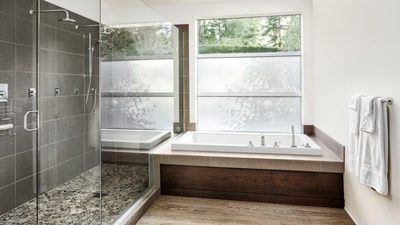 Une salle de bain avec baignoire, douche et fenêtre.