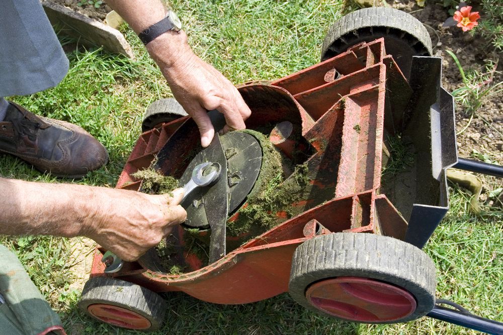Man Repairing Push Lawn Mower — Farm Equipment Experts In Mullumbimby, NSW