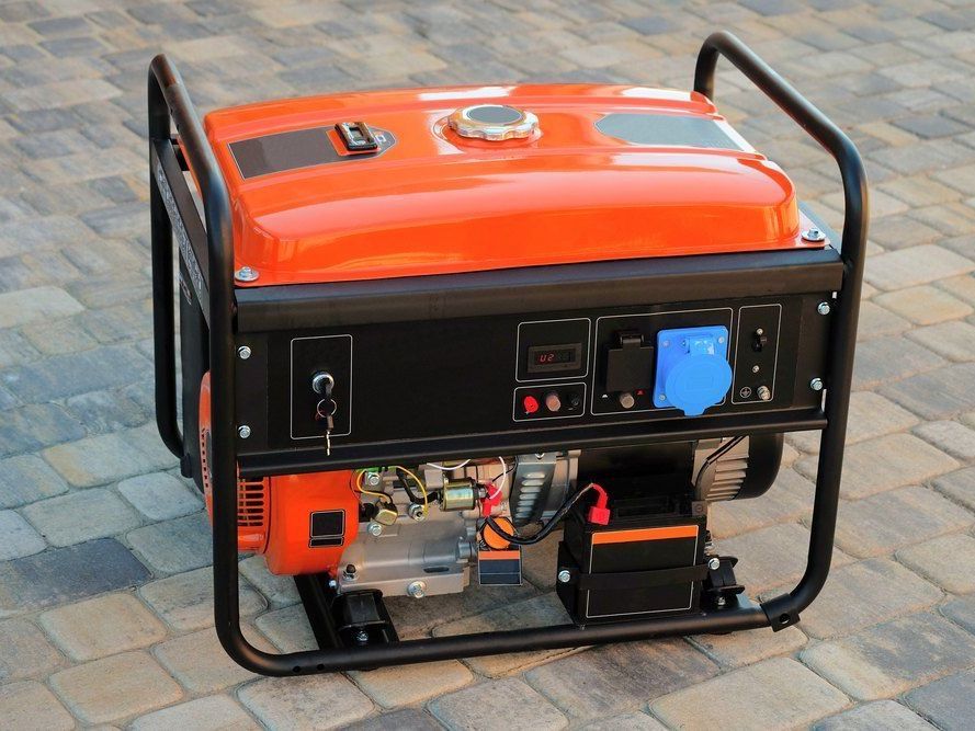 A Small Orange Generator is Sitting on a Brick Sidewalk — FarmCare in Mullumbimby, NSW