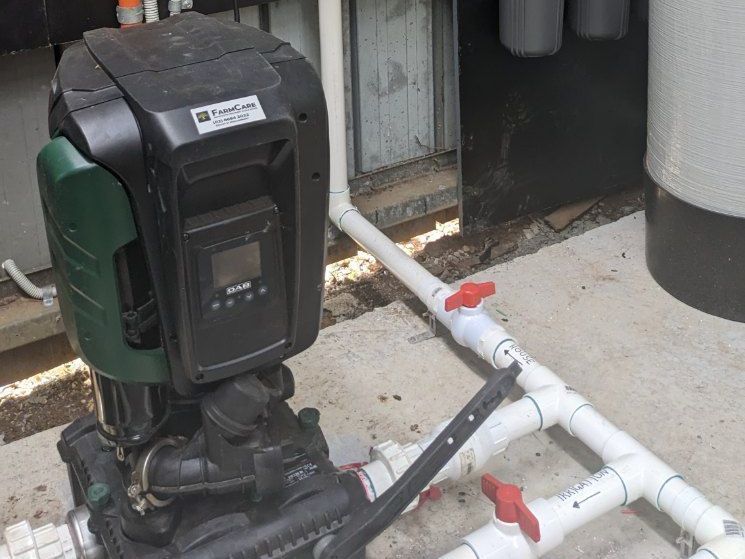 A Water Pump is Sitting Next to a Bunch of Pipes — FarmCare in Mullumbimby, NSW