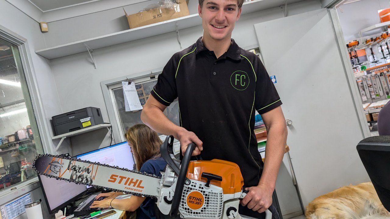 A Man is Holding a Stihl Chainsaw in a Room — FarmCare in Mullumbimby, NSW