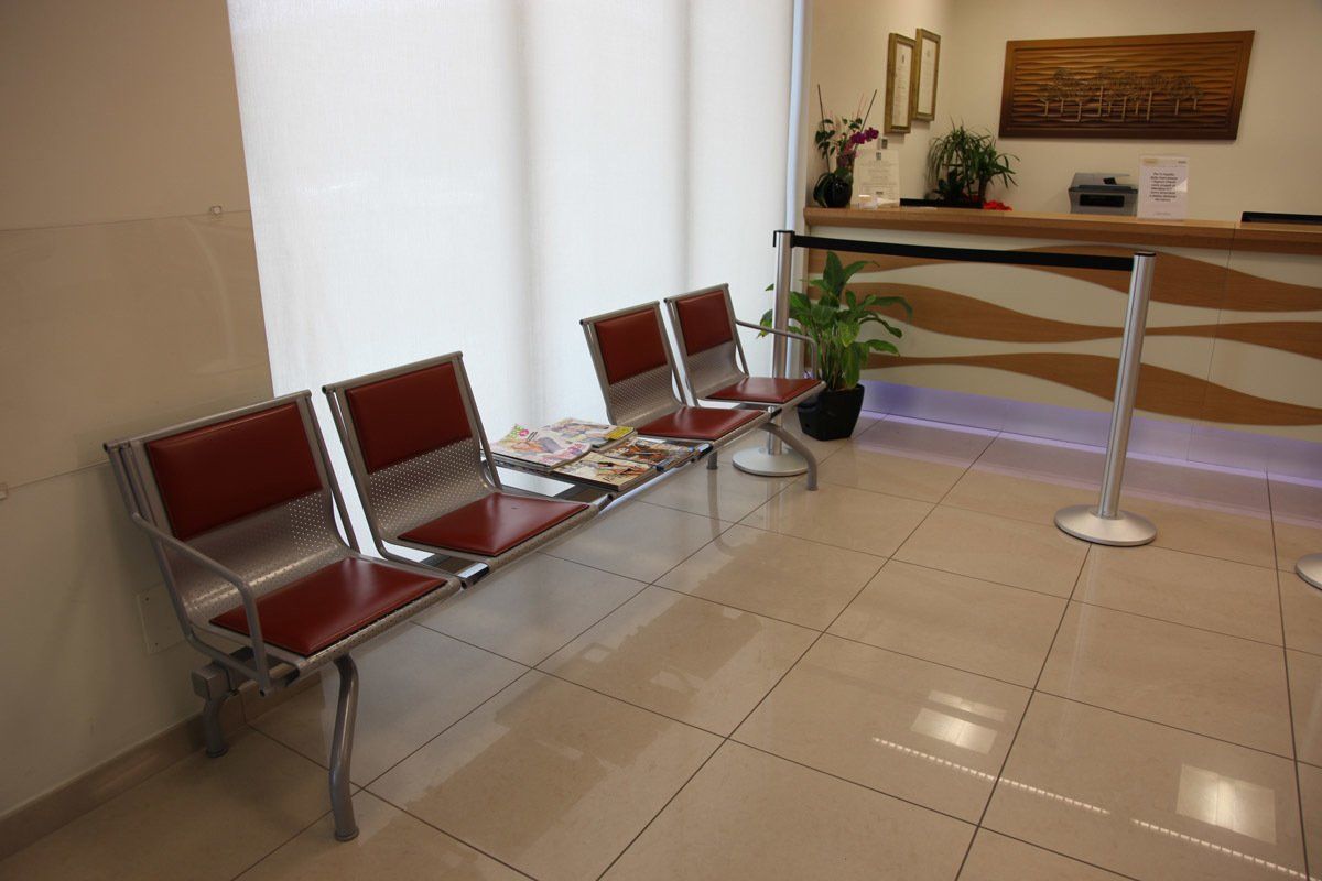 Una sala d'attesa con una fila di sedie e un bancone.