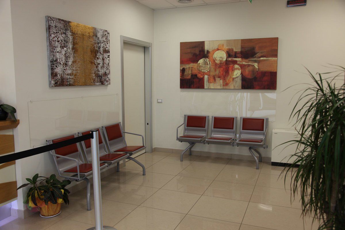 Una sala d'attesa con sedie e un quadro sul muro