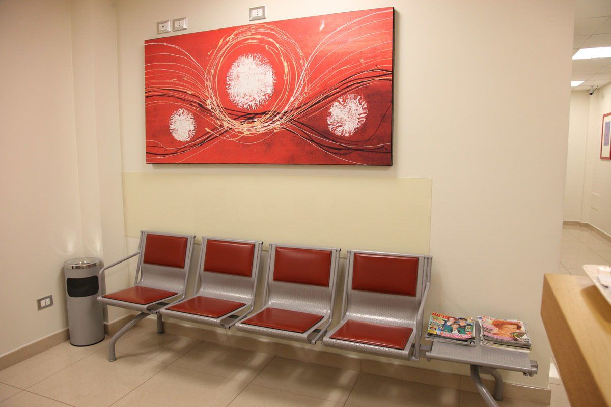 Una sala d'attesa con sedie e un quadro sul muro